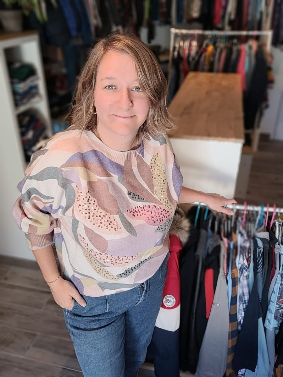 Sarah, fondatrice, avec une pile de vêtements triés